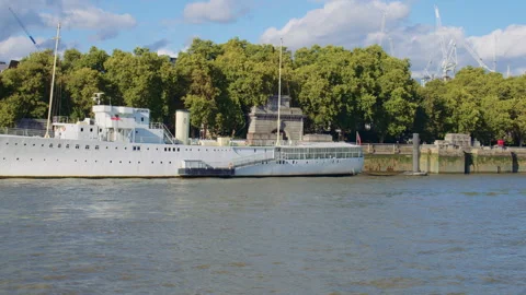 White ship moored on the River Thames with trees and blue sky in the background. Stock Footage 319808057
