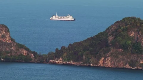 White Ship Passing Behind Rocky Tropical Island Through Natural Sea Gap Видео 333436627