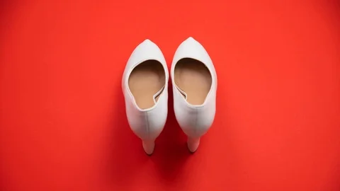White shoes isolated on solid red background in studio, walking up. Stock Footage 111655264