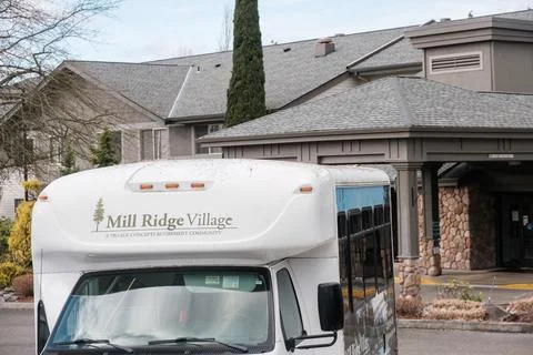A white shuttle bus for Mill Ridge Village retirement community parked in f.. Stock-Fotos