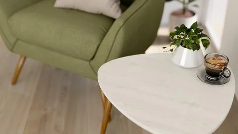 White side marble table with latte art coffee cup and potted plant beside g.. Illustrazione stock