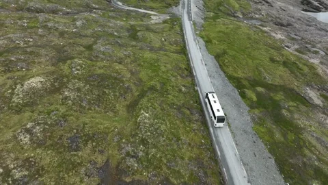 White sightseeing bus driving tourists at Vikafjellet mountain pass in Stock Footage 247633649