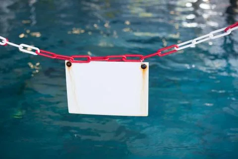White sign in front of a swimming pool Stock Photos