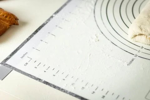 White silicone baking mat with centimeter and inch markings sprinkled with flour Stock Photos