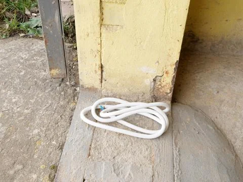 White silicone electrical cable with exposed conductors neatly coiled beside  Stock Photos