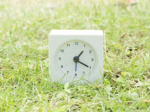 White simple clock on lawn yard, 1:20 one twenty Stock Photos