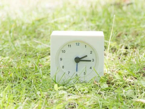 White simple clock on lawn yard, 2:15 two fifteen Stock Photos
