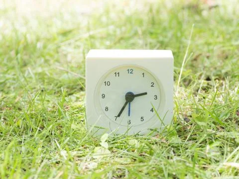 White simple clock on lawn yard, 2:35 two thirty  five Stock Photos