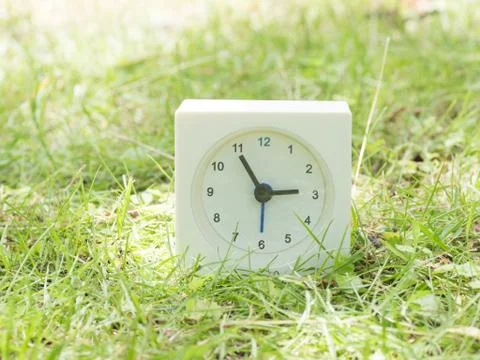 White simple clock on lawn yard, 2:55 two fifty five Stock Photos