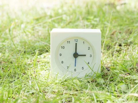 White simple clock on lawn yard, 3:00 three o'clock Foto stock