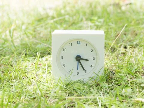 White simple clock on lawn yard, 3:25 three twenty five Foto stock
