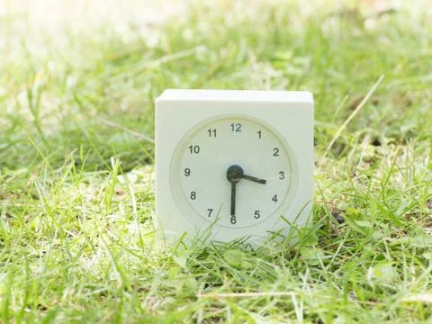White simple clock on lawn yard, 3:30 three thirty half Stock Photos