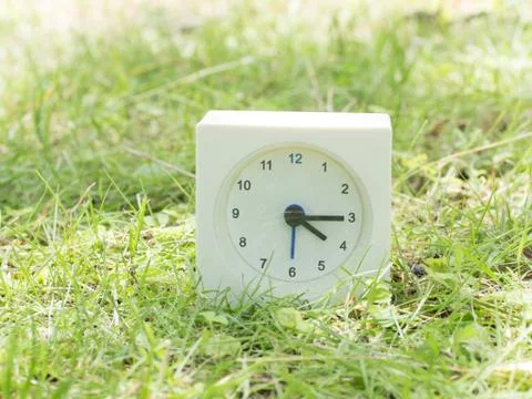White simple clock on lawn yard, 4:15 four fifteen Stock Photos