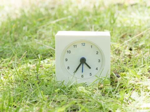 White simple clock on lawn yard, 4:35 four thirty five Stock Photos