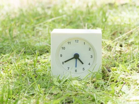 White simple clock on lawn yard, 4:40 four forty Stock Photos