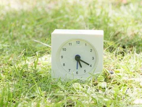 White simple clock on lawn yard, 5:20 five twenty Stock Photos