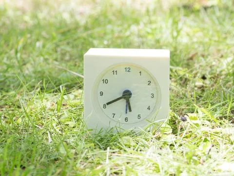 White simple clock on lawn yard, 5:40 five forty Stock Photos