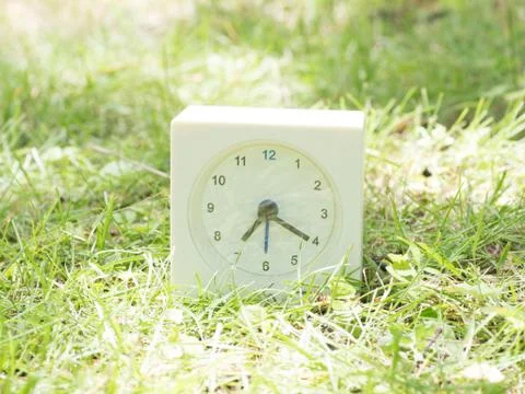 White simple clock on lawn yard, 7:20 seven twenty Foto stock