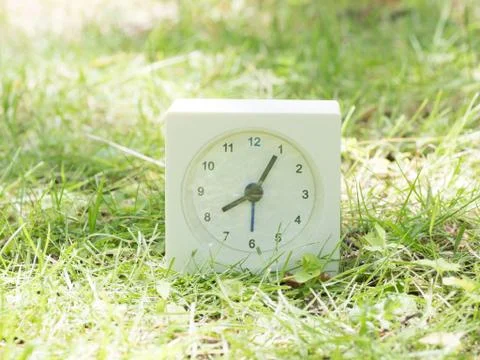 White simple clock on lawn yard, 8:05 eight five Stock Photos