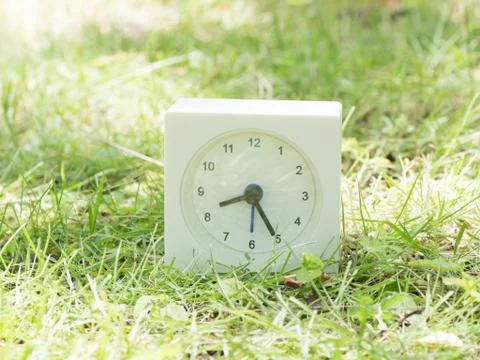 White simple clock on lawn yard, 8:25 eight twenty five Stock Photos