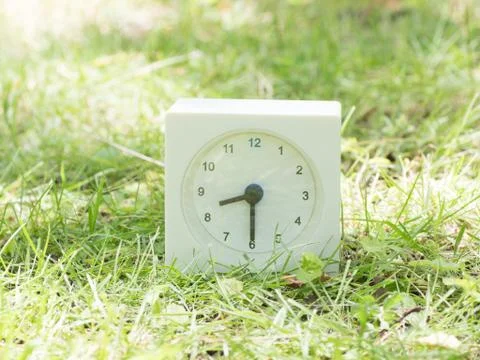 White simple clock on lawn yard, 8:30 eight thirty half Stock Photos
