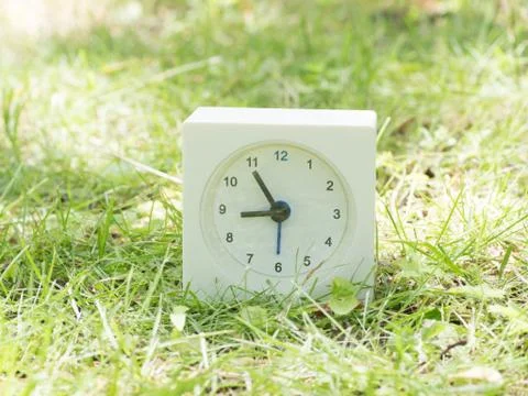 White simple clock on lawn yard, 8:55 eight fifty five Stock Photos