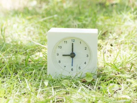 White simple clock on lawn yard, 9:00 nine o'clock Stock Photos