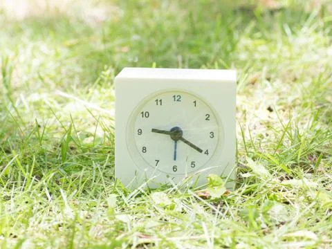 White simple clock on lawn yard, 9:20 nine twenty Stock Photos