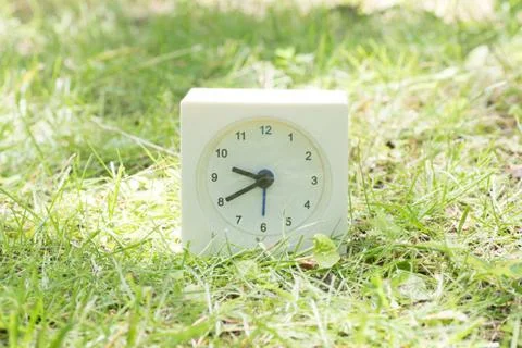 White simple clock on lawn yard, 9:40 nine forty Stock Photos