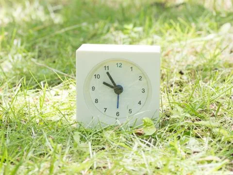 White simple clock on lawn yard, 9:55 nine fifty five Foto stock