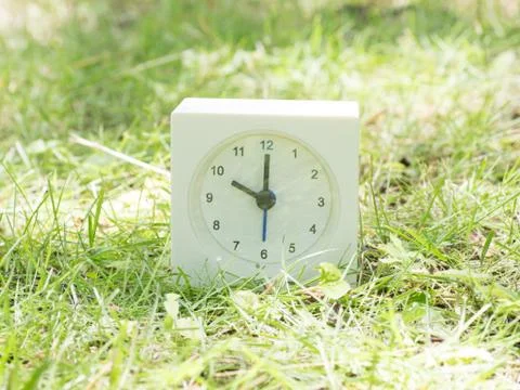 White simple clock on lawn yard, 10:00 ten o'clock Stock Photos