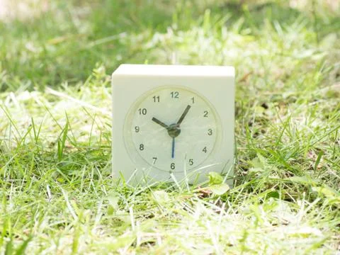 White simple clock on lawn yard, 10:05 ten five Stock Photos