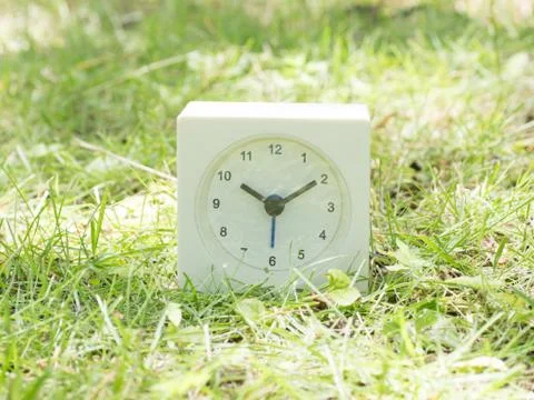 White simple clock on lawn yard, 10:10 ten ten Stock Photos