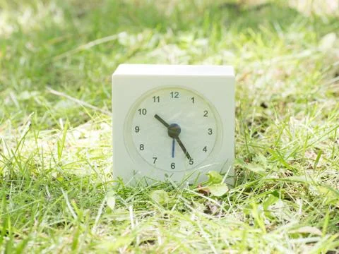 White simple clock on lawn yard, 10:25 ten twenty five Stock Photos