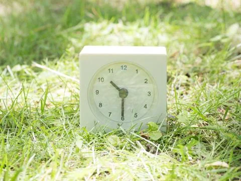 White simple clock on lawn yard, 10:30 ten thirty half Stock Photos