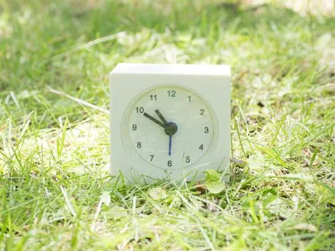 White simple clock on lawn yard, 10:50 ten fifty Stock Photos