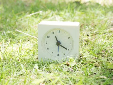 White simple clock on lawn yard, 11:20 eleven twenty Stock Photos