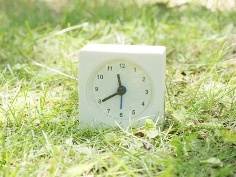 White simple clock on lawn yard, 11:40 eleven forty Stock Photos