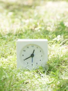White simple clock on lawn yard, 12:40 twelve forty Stock Photos