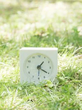 White simple clock on lawn yard, 1:20 one twenty Stock Photos