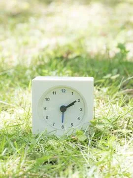 White simple clock on lawn yard, 2:10 two ten Stock Photos