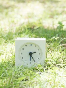 White simple clock on lawn yard, 2:25 two twenty five Stock Photos