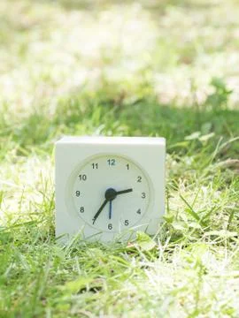 White simple clock on lawn yard, 2:35 two thirty  five Stock Photos