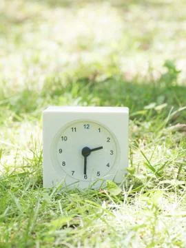White simple clock on lawn yard, 2:30 two thirty half Stock Photos