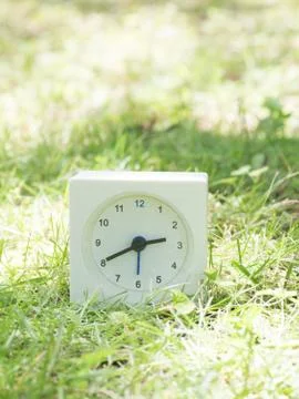 White simple clock on lawn yard, 2:40 two forty Stock Photos