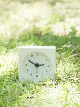 White simple clock on lawn yard, 2:50 two fifty Stock Photos