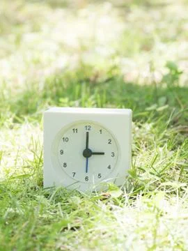 White simple clock on lawn yard, 3:00 three o'clock Stock Photos