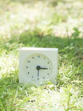 White simple clock on lawn yard,  3:15 three fifteen Stock Photos