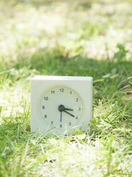 White simple clock on lawn yard, 3:20 three twenty Stock Photos