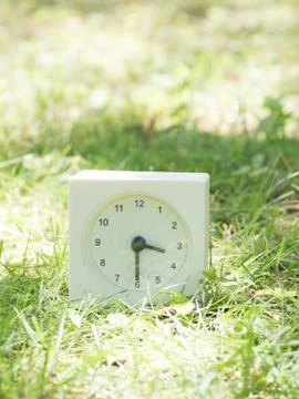 White simple clock on lawn yard, 3:30 three thirty half Stock Photos